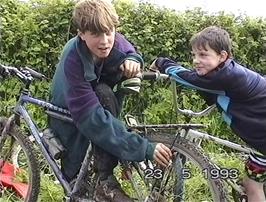 Chris Platt cleans the mud off his bike, watched by Peter Bonnet